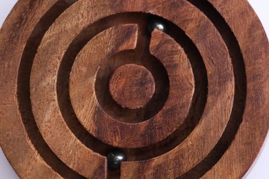 Photo of Wooden toy maze with metal balls, closeup