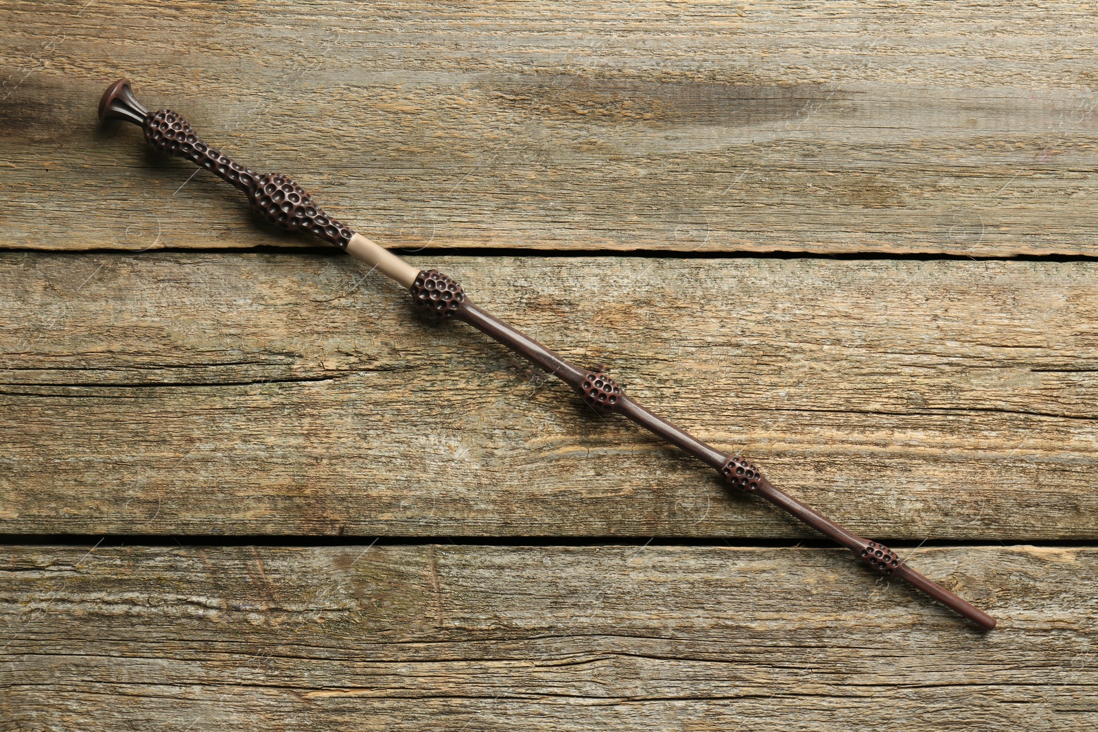 Photo of One old magic wand on wooden table, top view