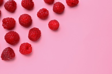 Photo of Tasty ripe raspberries on pink background, flat lay. Space for text