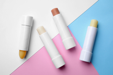 Hygienic lipsticks on color background, flat lay