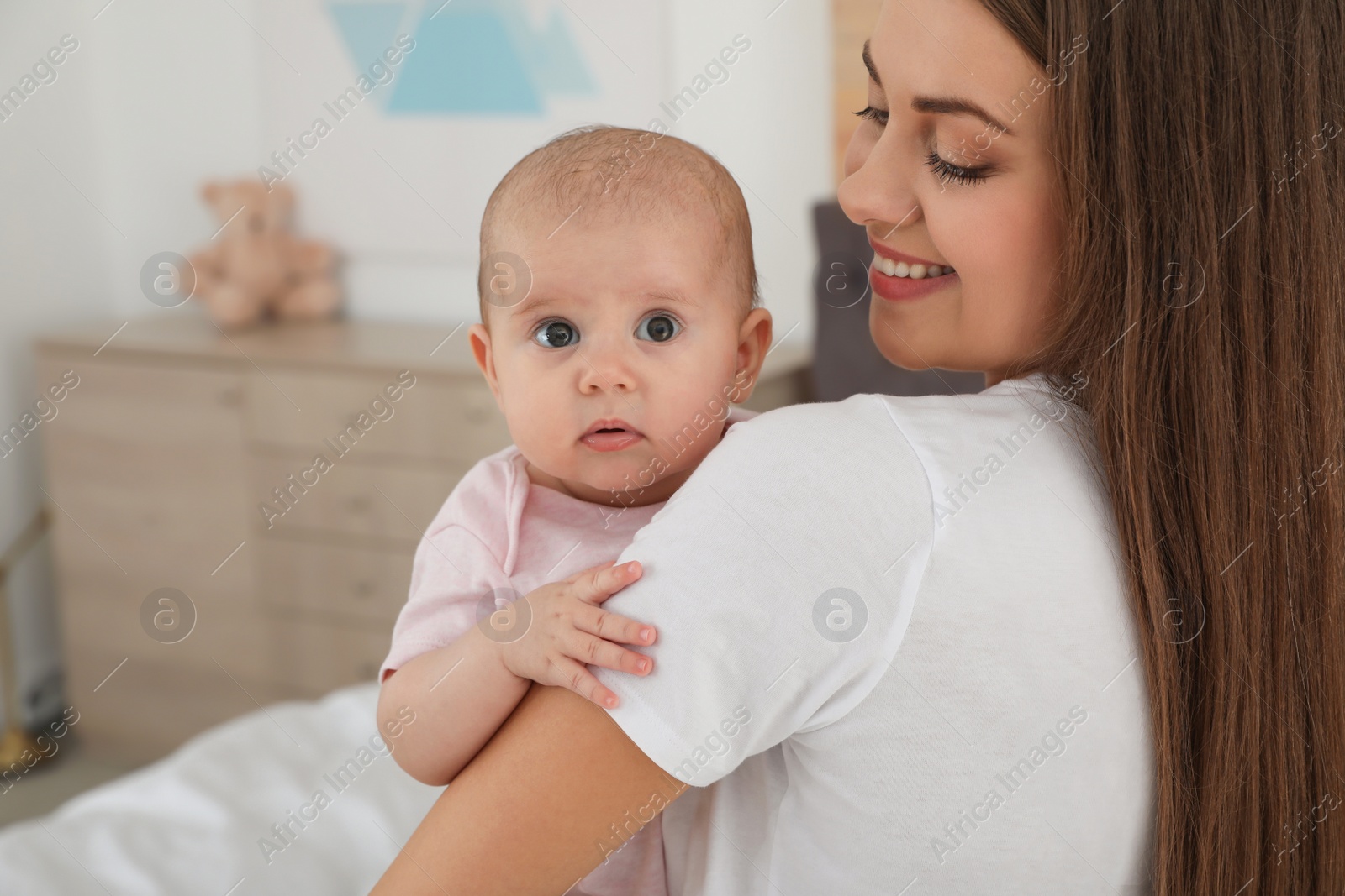 Photo of Mother holding her adorable baby at home