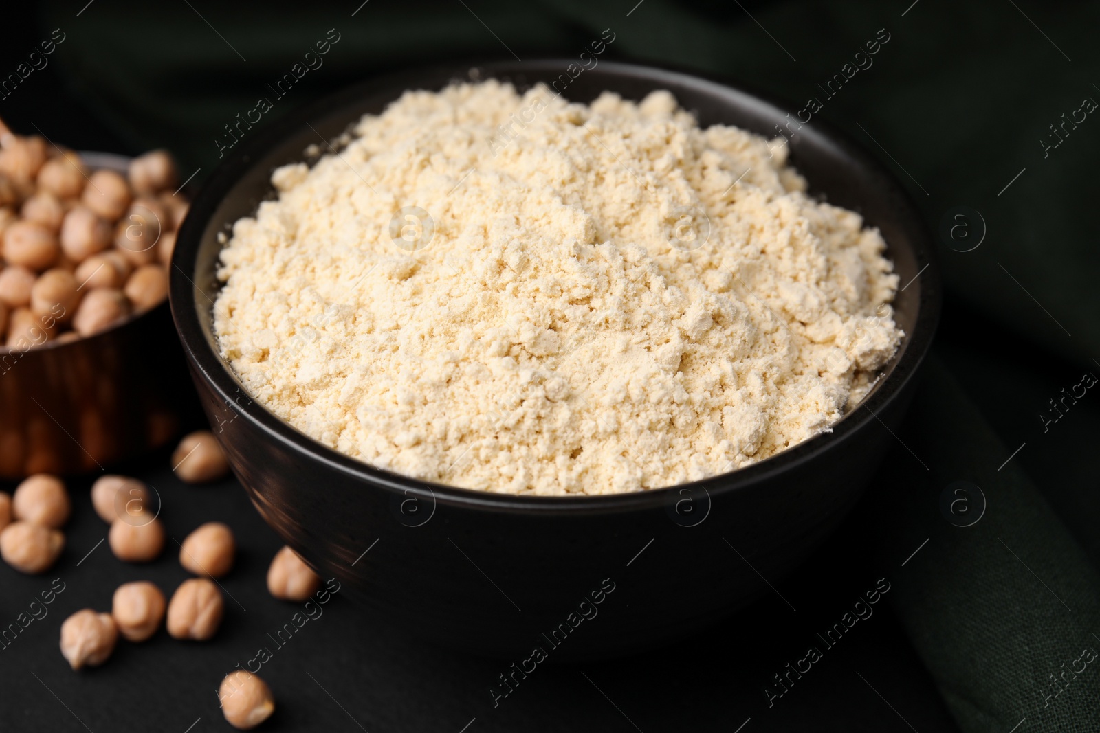 Photo of Chickpea flour in bowl and seeds on black table