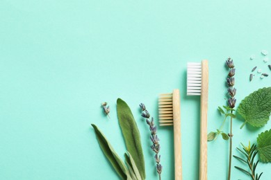Photo of Flat lay composition with bamboo toothbrushes and herbs on turquoise background. Space for text