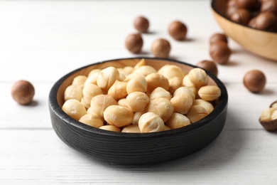Photo of Plate with shelled organic Macadamia nuts on white table