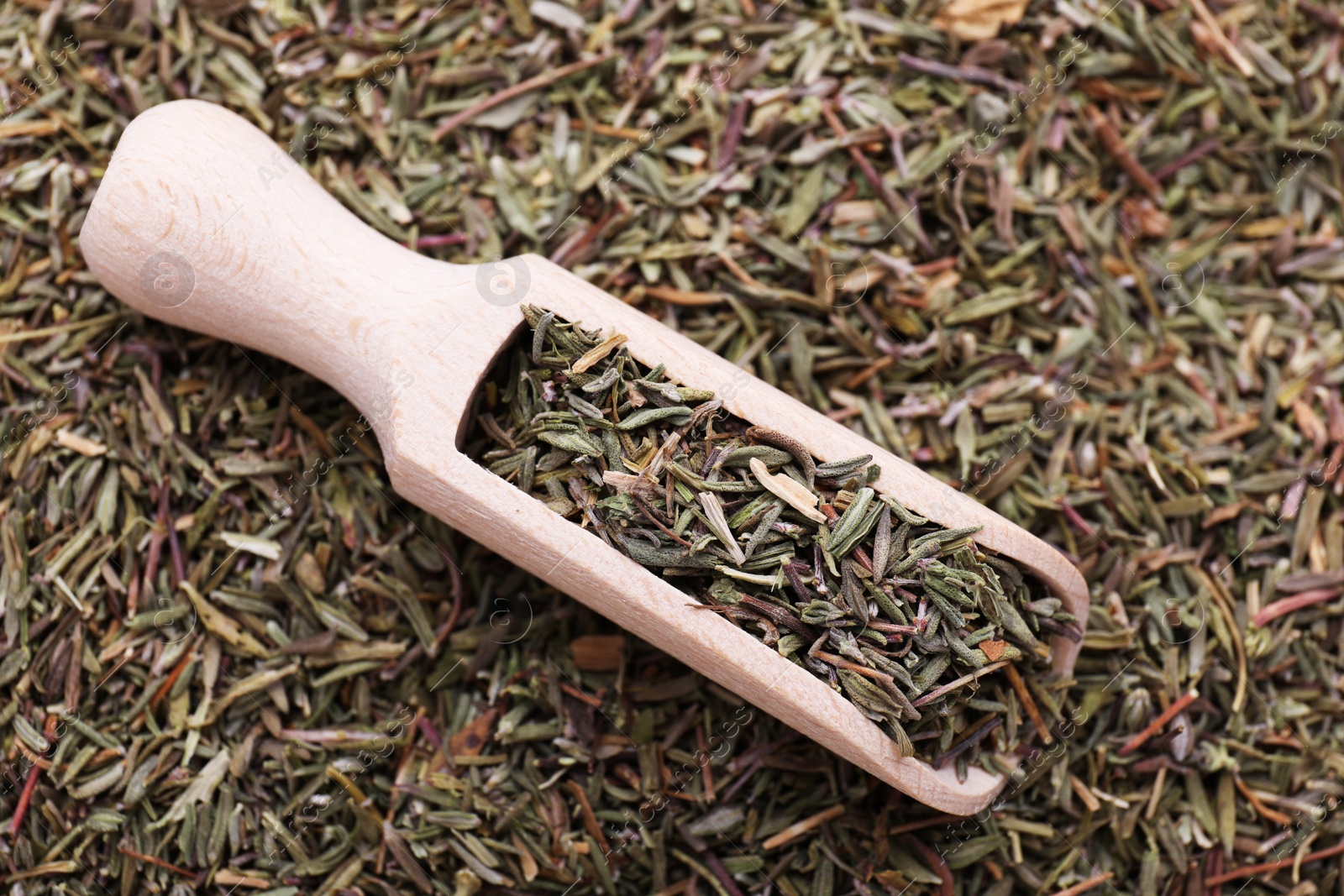 Photo of Wooden scoop with dried thyme, top view