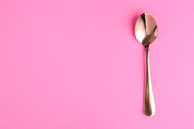 Photo of Clean tea spoon and space for text on color background, top view