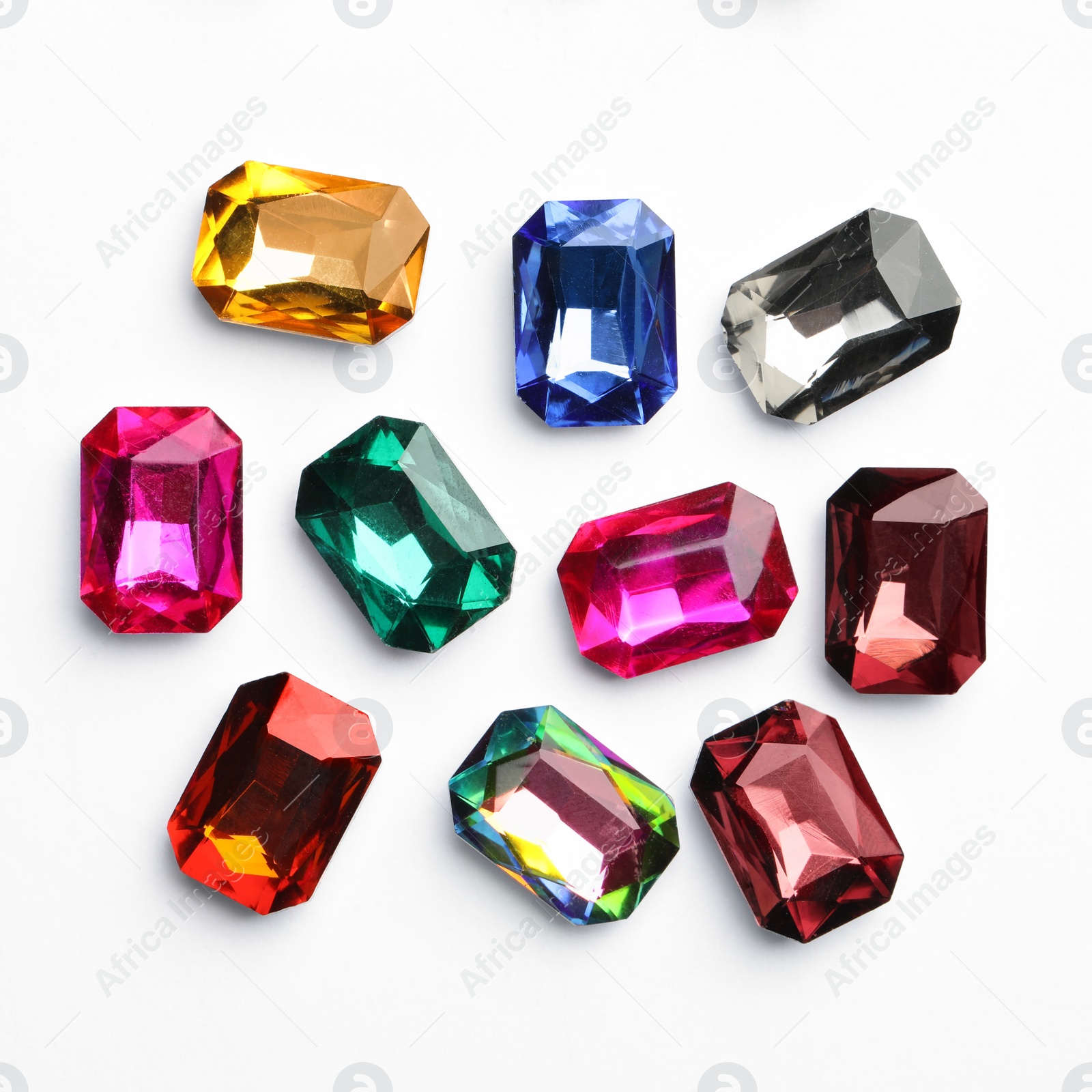 Image of Different beautiful gemstones on white background, top view