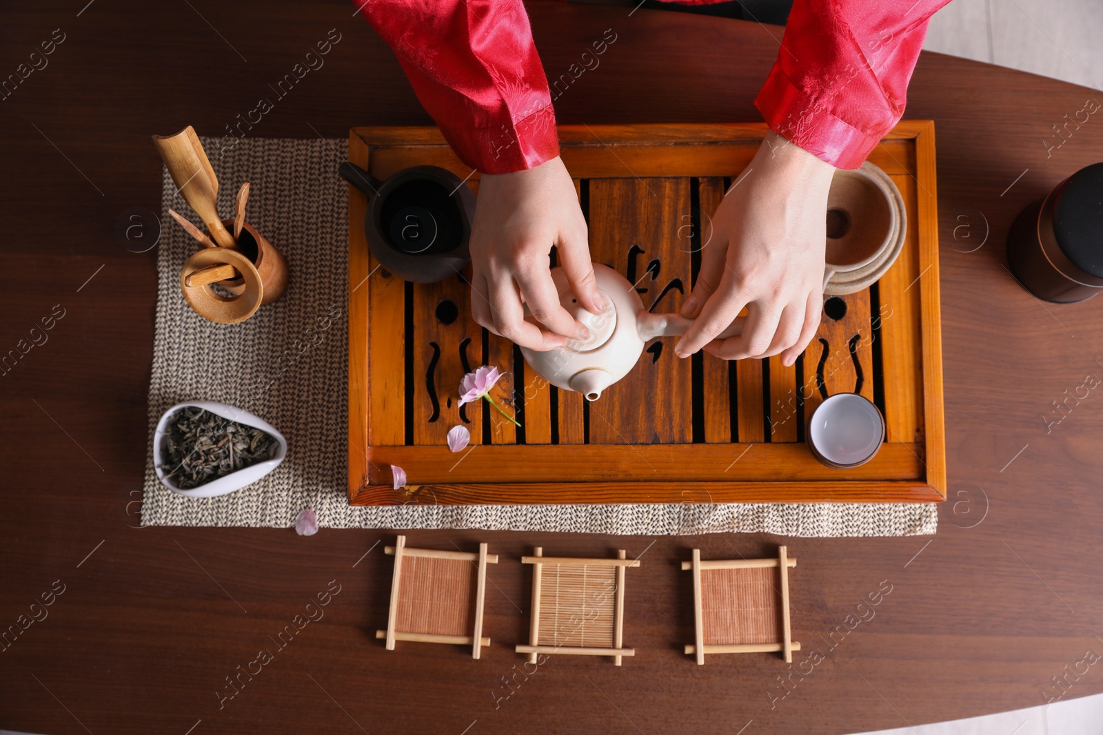 Photo of Master conducting traditional tea ceremony at wooden table, top view