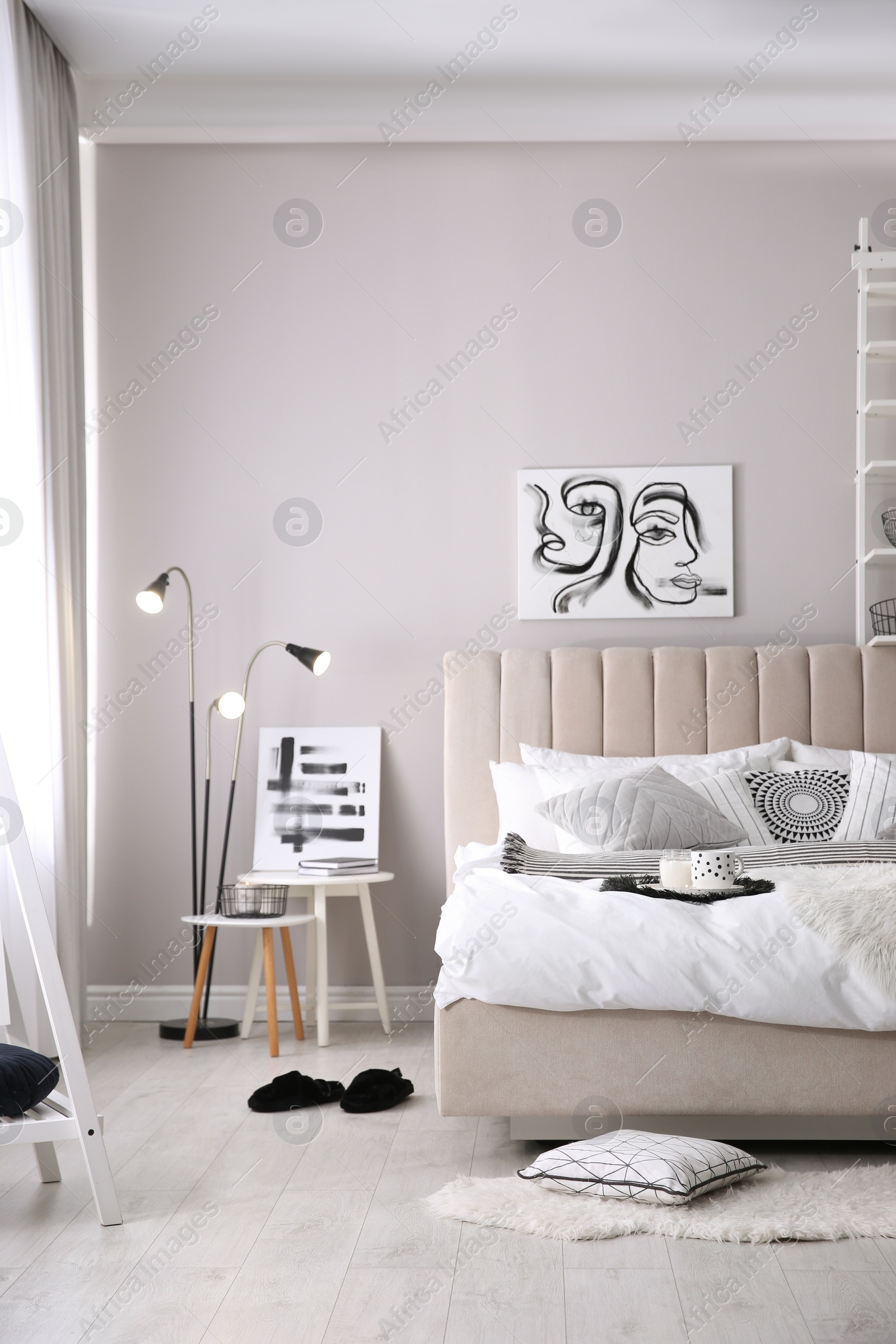 Photo of Cozy bedroom interior with cushions and beautiful pictures