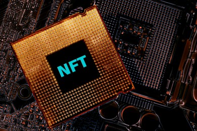 Image of Abbreviation NFT (non-fungible token) on microchip and computer motherboard, top view