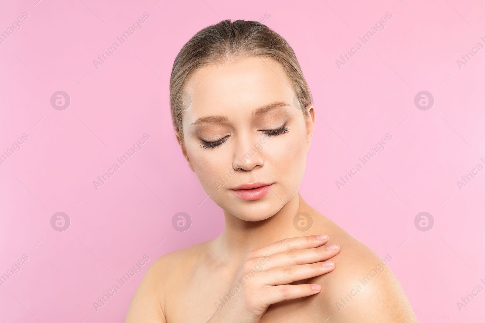 Photo of Portrait of young woman with beautiful face on pink background