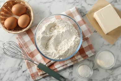 Making shortcrust pastry. Different ingredients for dough and whisk on white marble table, flat lay