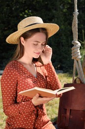 Photo of Beautiful young woman reading book outdoors on sunny day