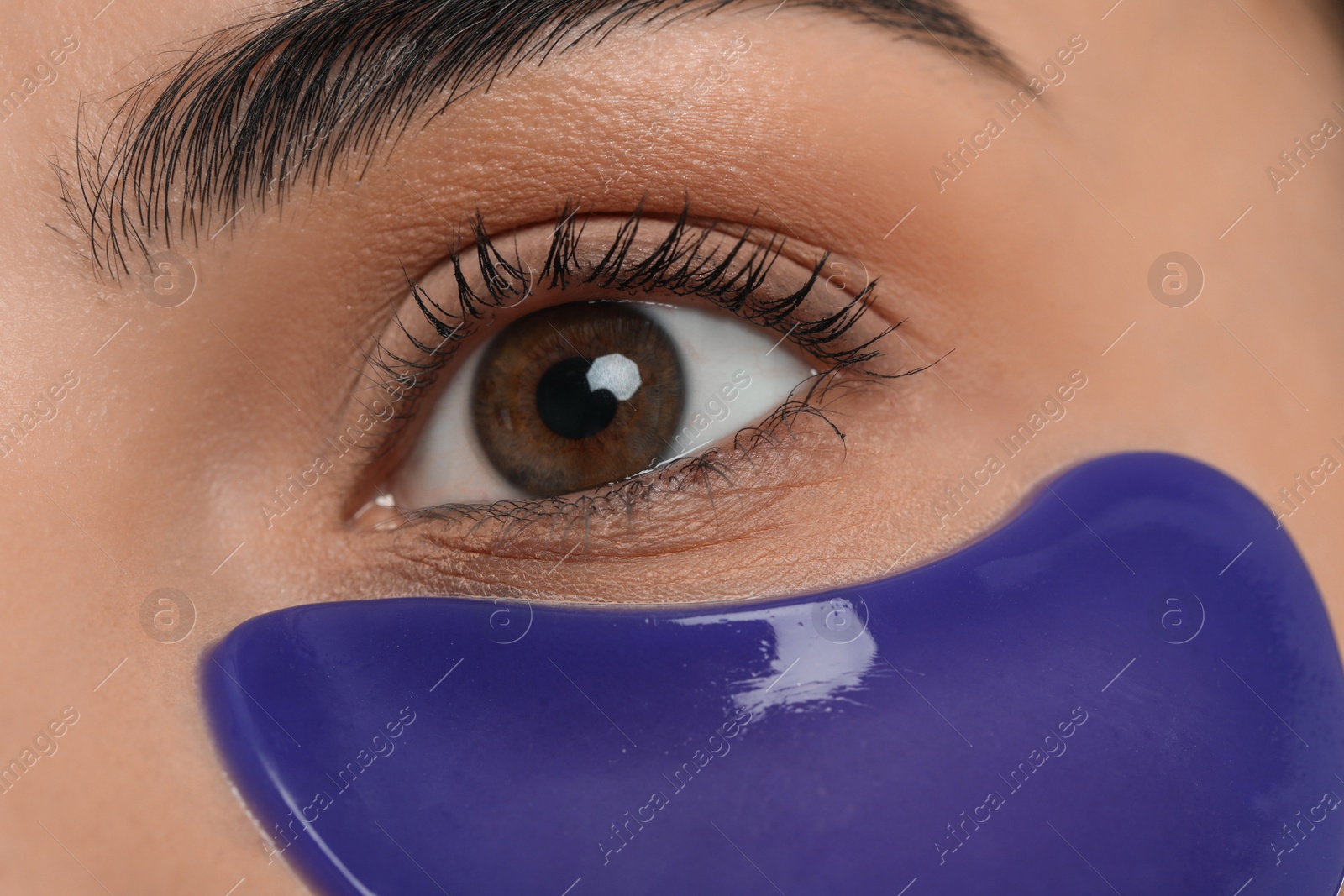 Photo of Young woman with blue under eye patch, closeup