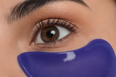 Young woman with blue under eye patch, closeup