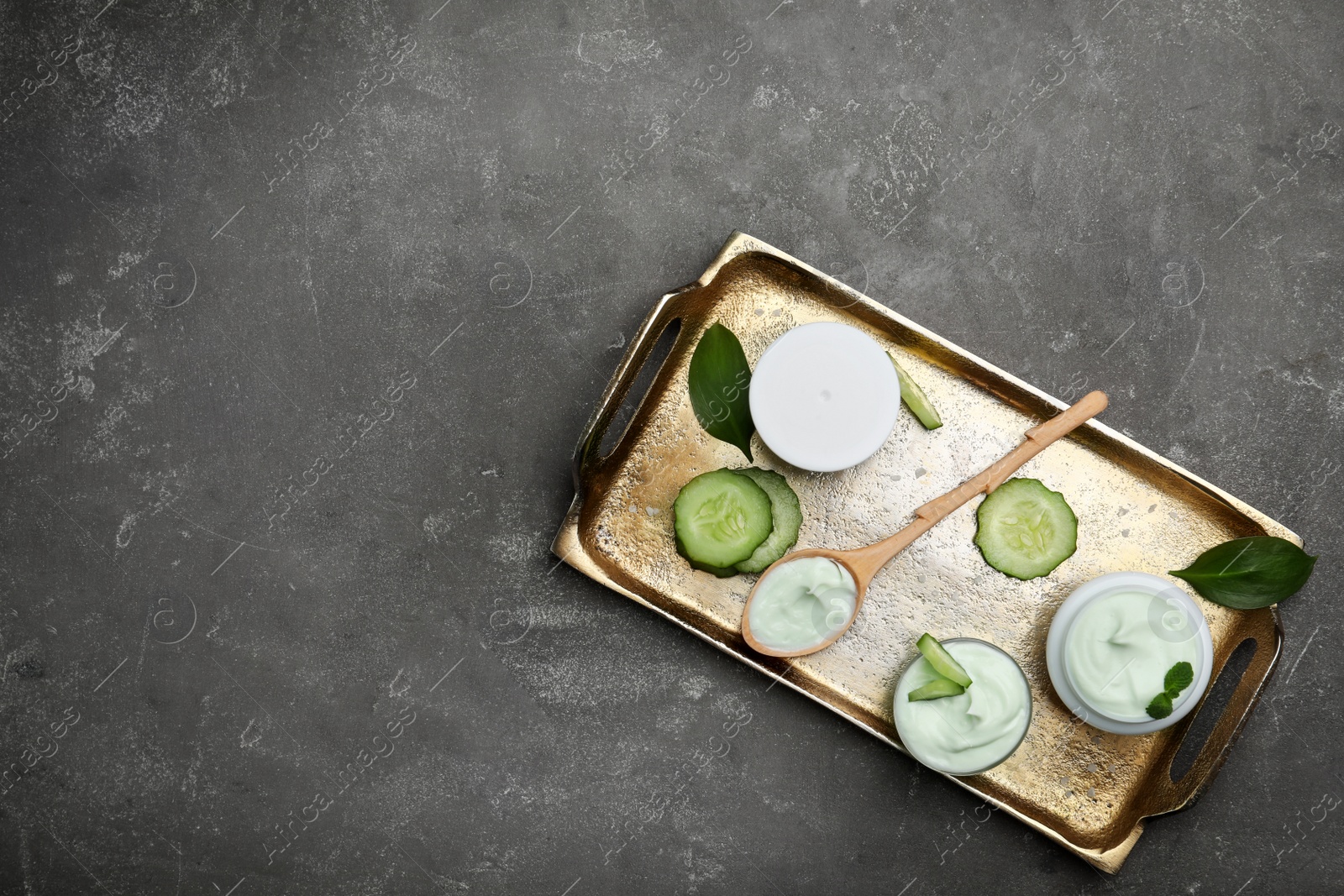 Photo of Composition with body cream in jars on grey background, top view