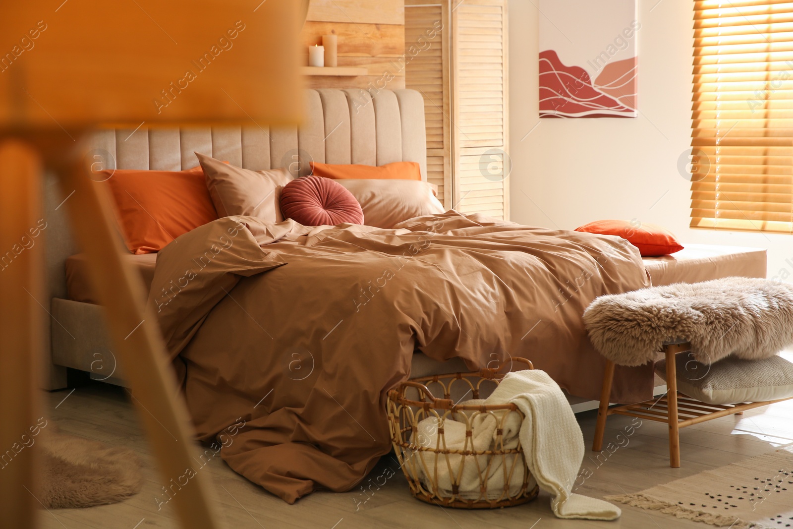 Photo of Bed with brown linens in cozy bedroom. Interior design