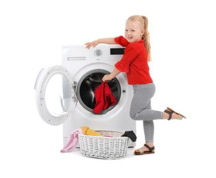 Photo of Cute little girl putting dirty laundry into washing machine on white background