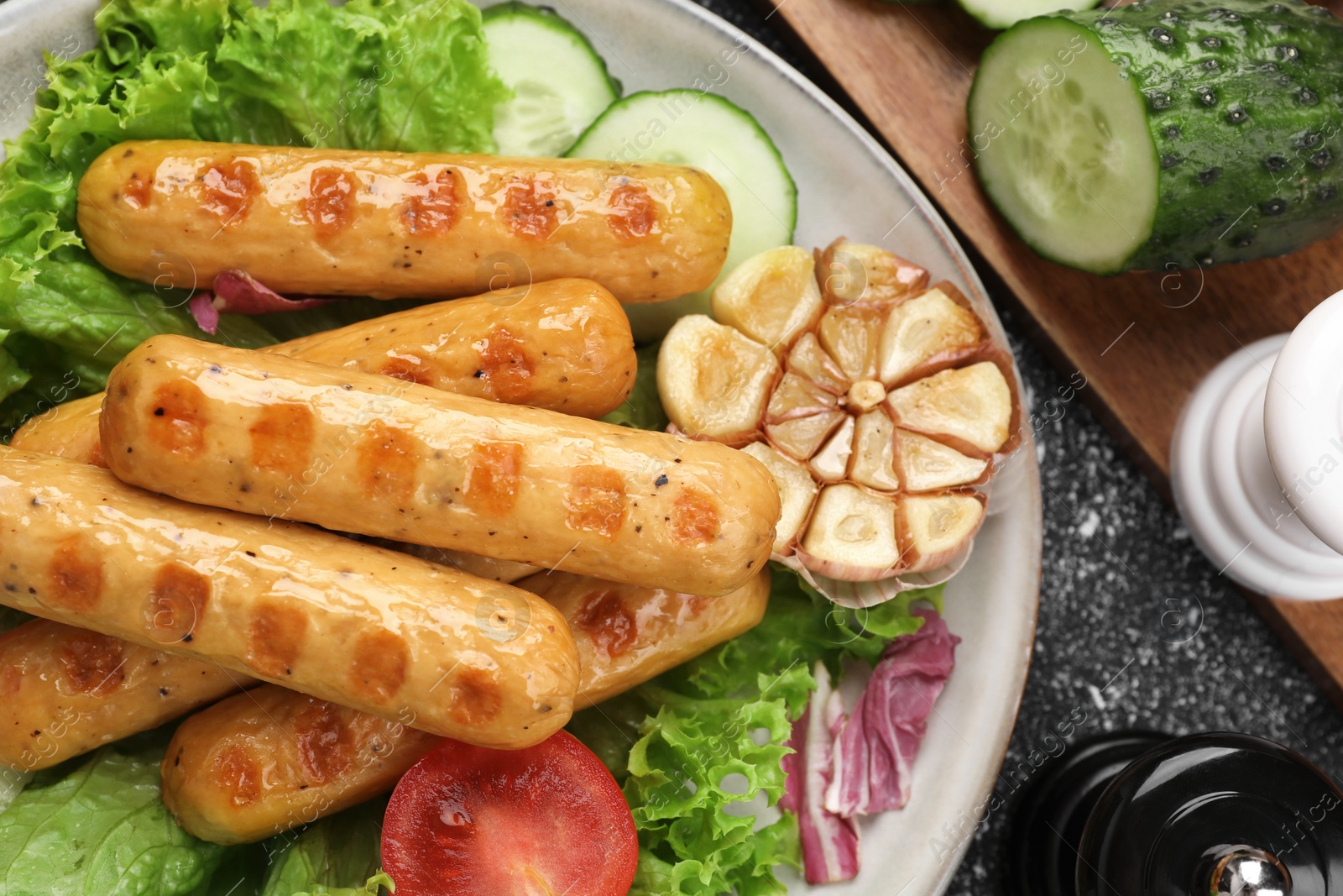 Photo of Delicious grilled vegan sausages with fresh herbs and vegetables on grey table, flat lay