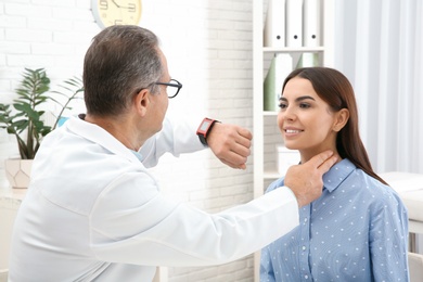 Photo of Doctor checking young woman's pulse with fingers in hospital