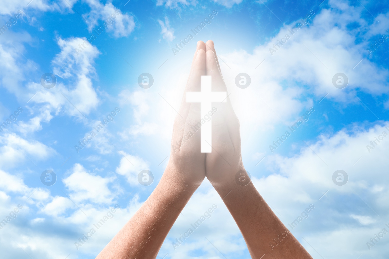 Image of Religion. Christian man with glowing cross praying against sky, closeup