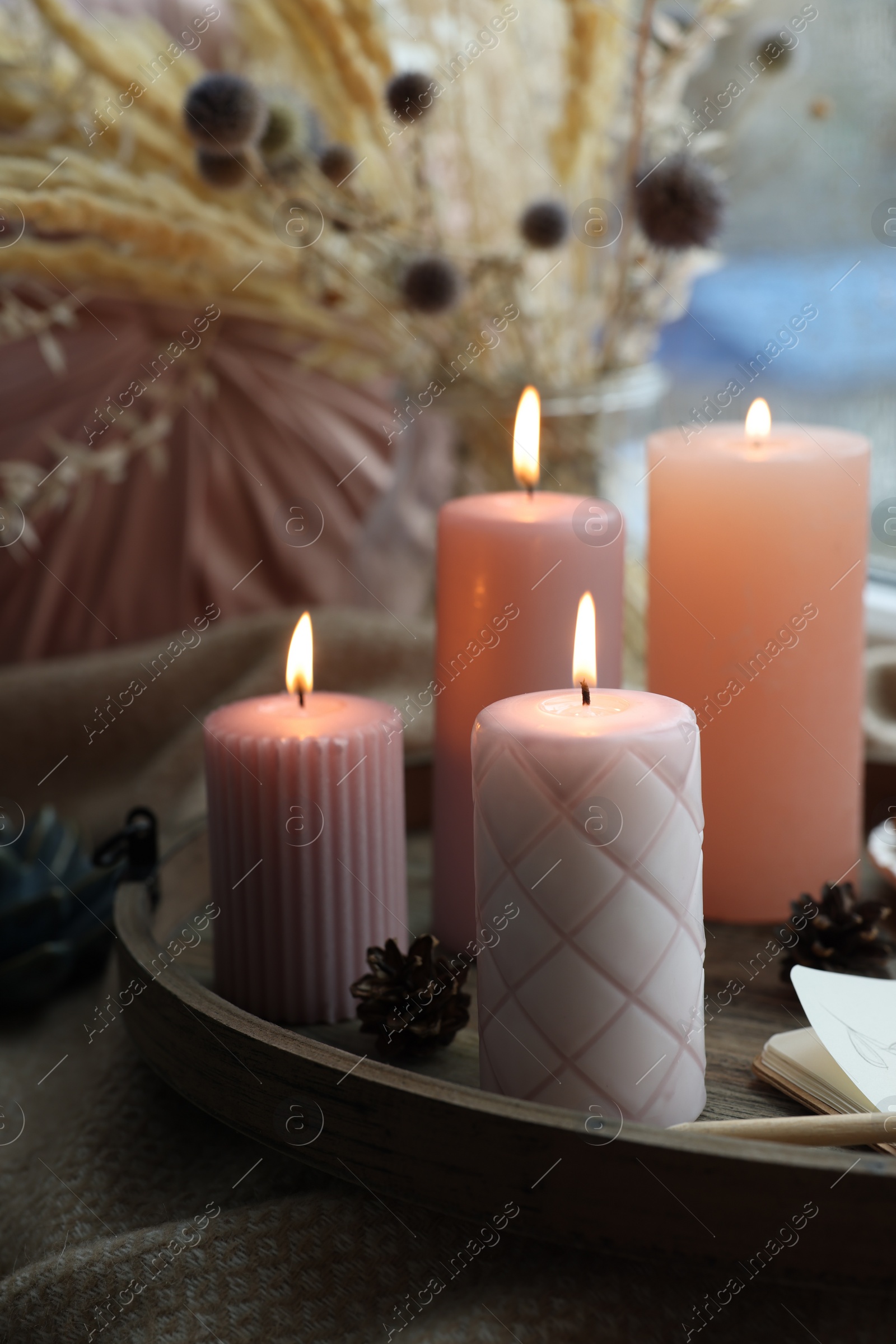 Photo of Tray with burning wax candles on window sill indoors