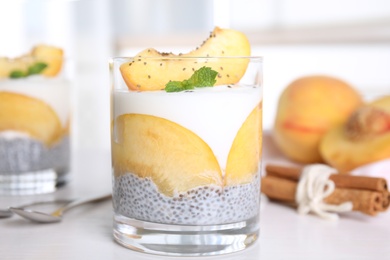 Tasty peach dessert with yogurt and chia seeds on white wooden table