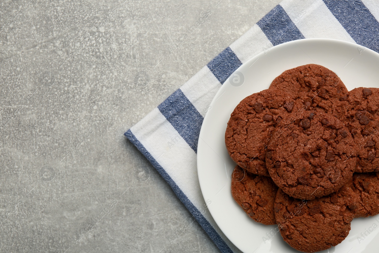 Photo of Delicious chocolate chip cookies on light grey table, top view. Space for text