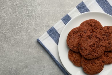 Delicious chocolate chip cookies on light grey table, top view. Space for text