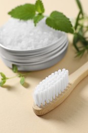 Toothbrush, salt and herbs on beige background, closeup.
