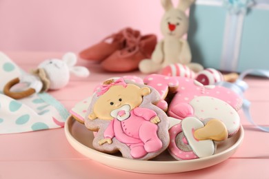 Photo of Tasty cookies of different shapes on pink wooden table. Baby shower party