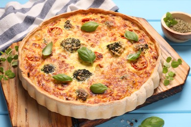 Photo of Delicious homemade vegetable quiche on light blue table