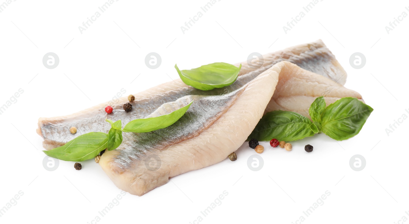 Photo of Delicious salted herring fillets with basil and peppercorns on white background