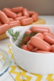 Photo of Bowl of delicious sausages and dill on white wooden table