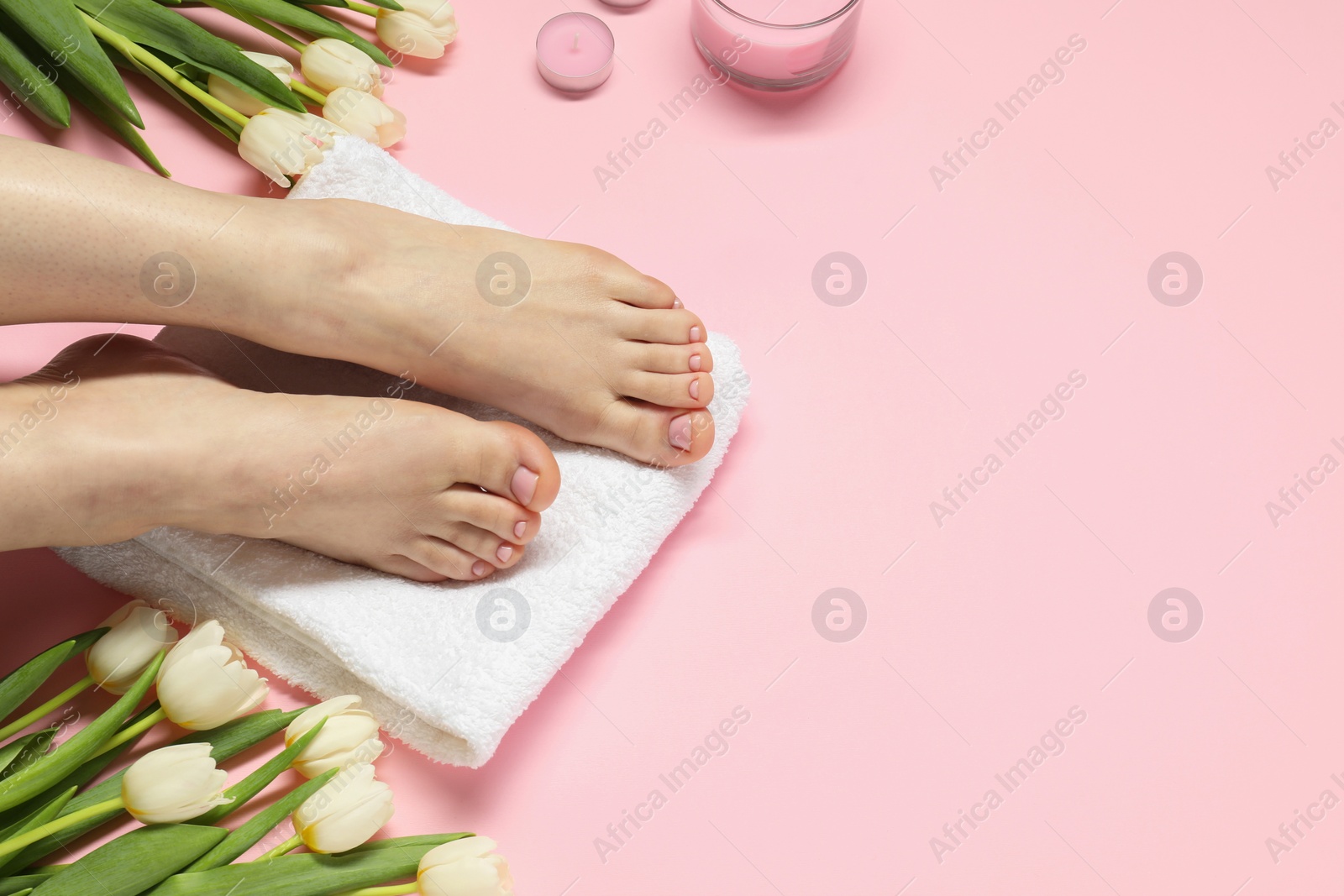 Photo of Woman with neat toenails after pedicure procedure on pink background, closeup. Space for text