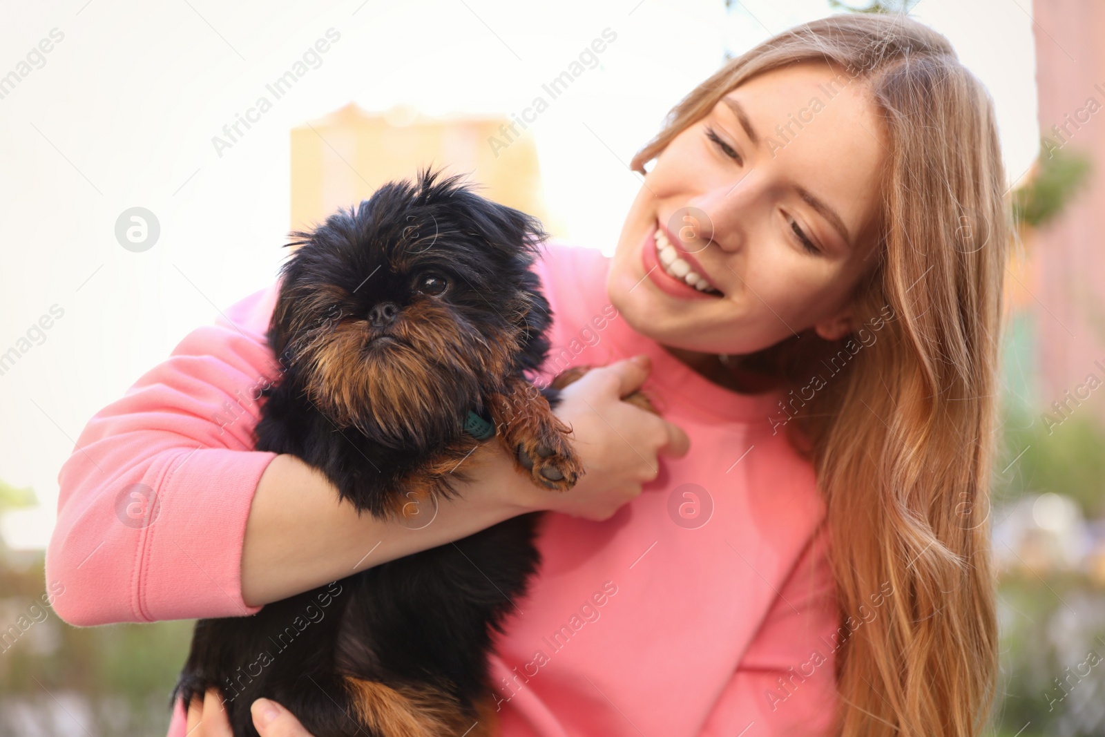 Photo of Young woman with adorable Brussels Griffon dog outdoors
