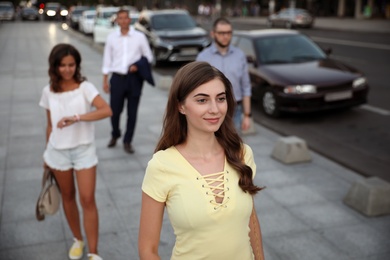 Photo of Young beautiful woman walking on modern city street