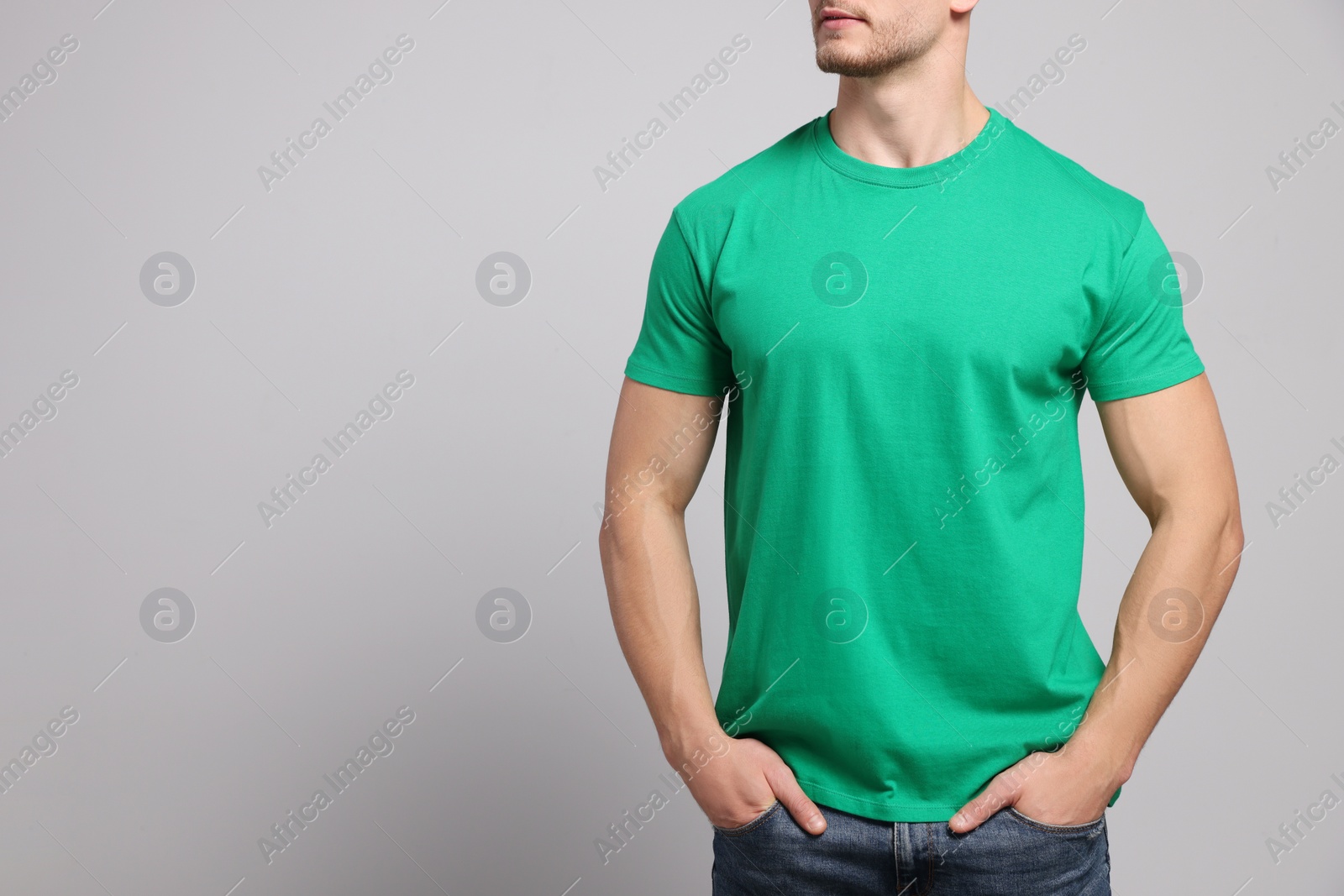 Photo of Man wearing green t-shirt on light grey background, closeup. Mockup for design