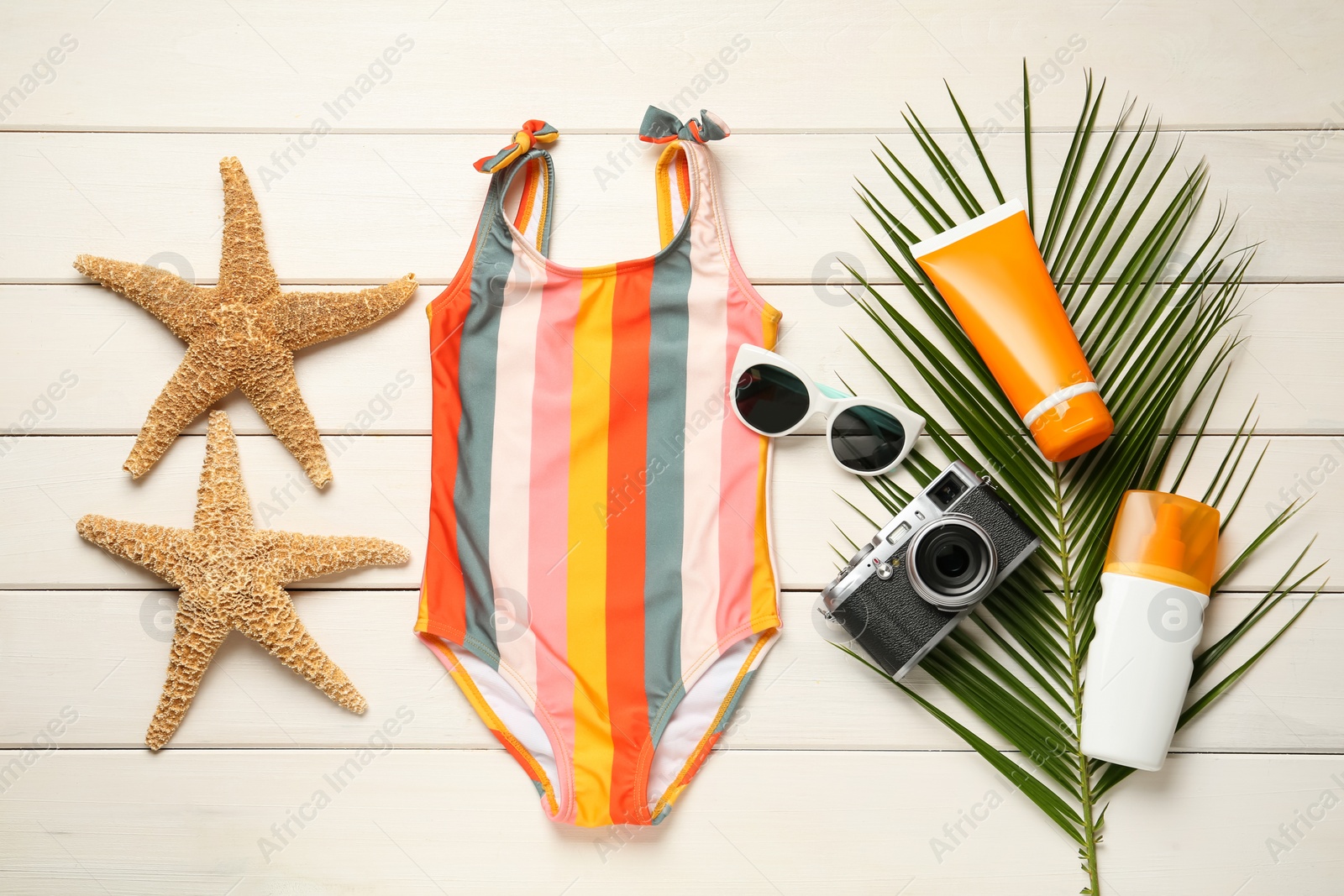 Photo of Flat lay composition with beach accessories on white wooden background
