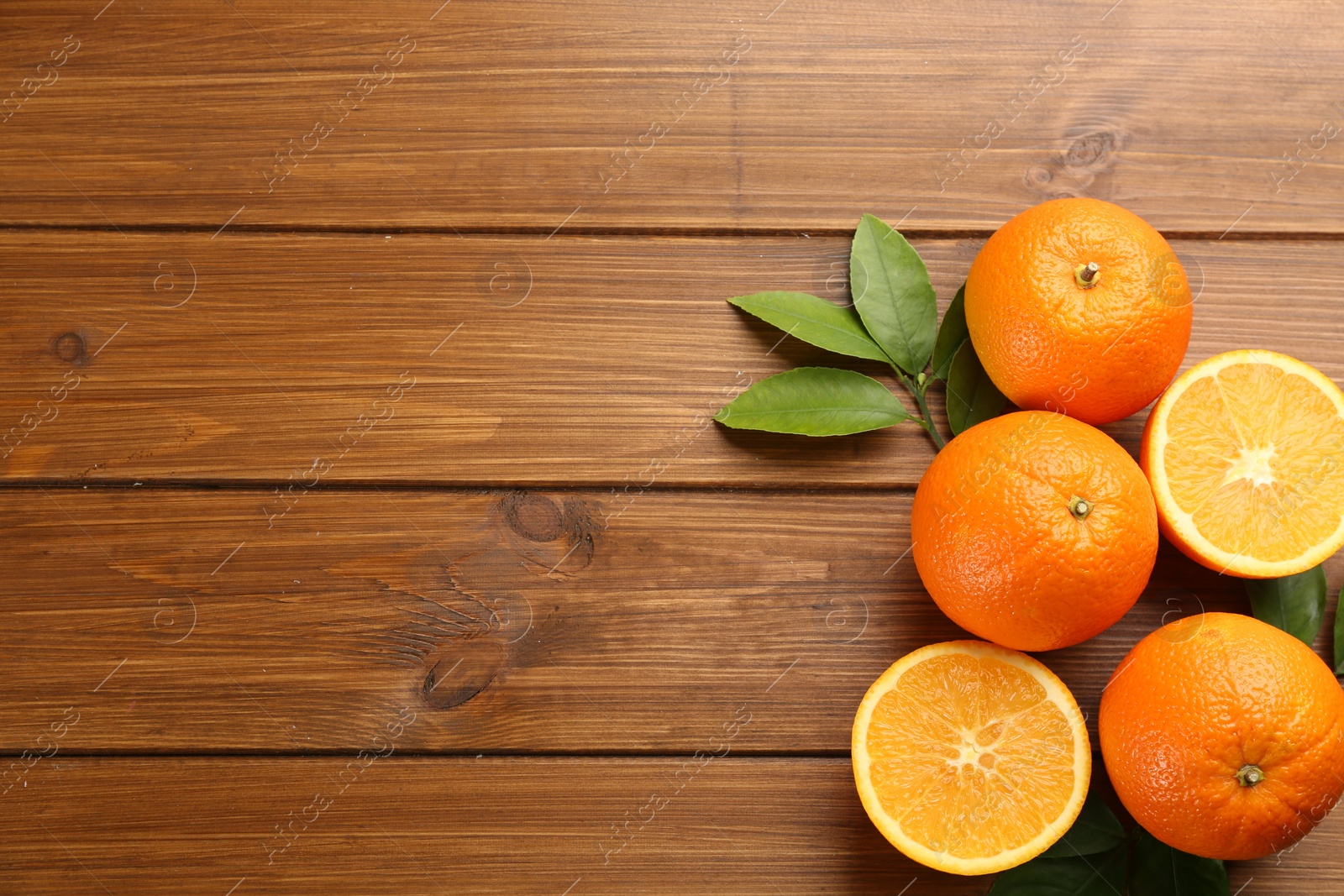 Photo of Delicious ripe oranges on wooden table, flat lay. Space for text