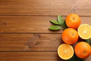 Delicious ripe oranges on wooden table, flat lay. Space for text