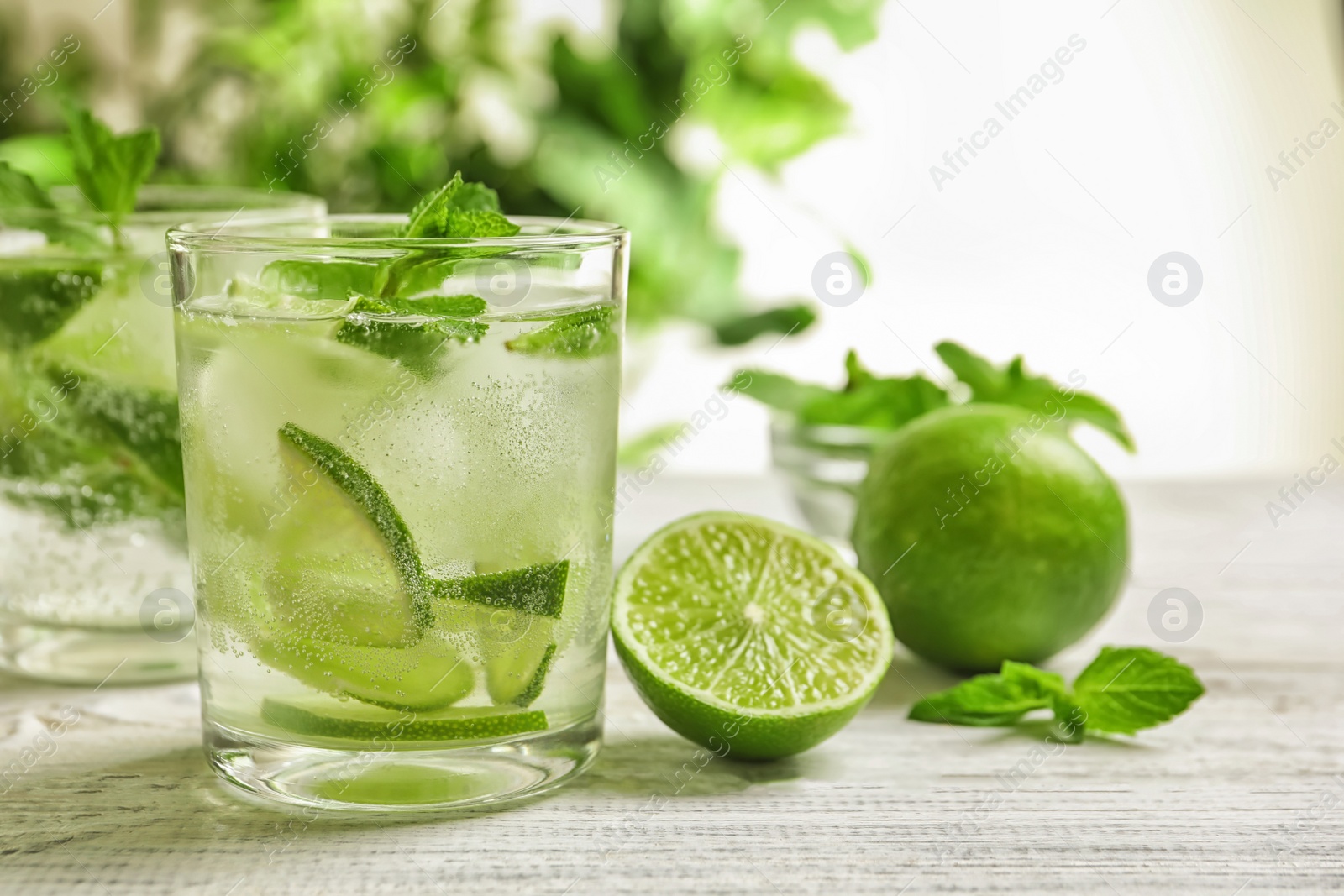 Photo of Refreshing beverage with mint and lime on table