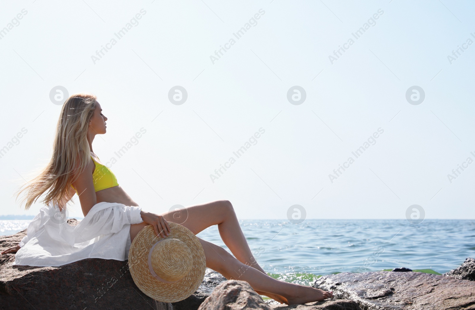 Photo of Beautiful young woman with straw hat near sea on sunny day in summer