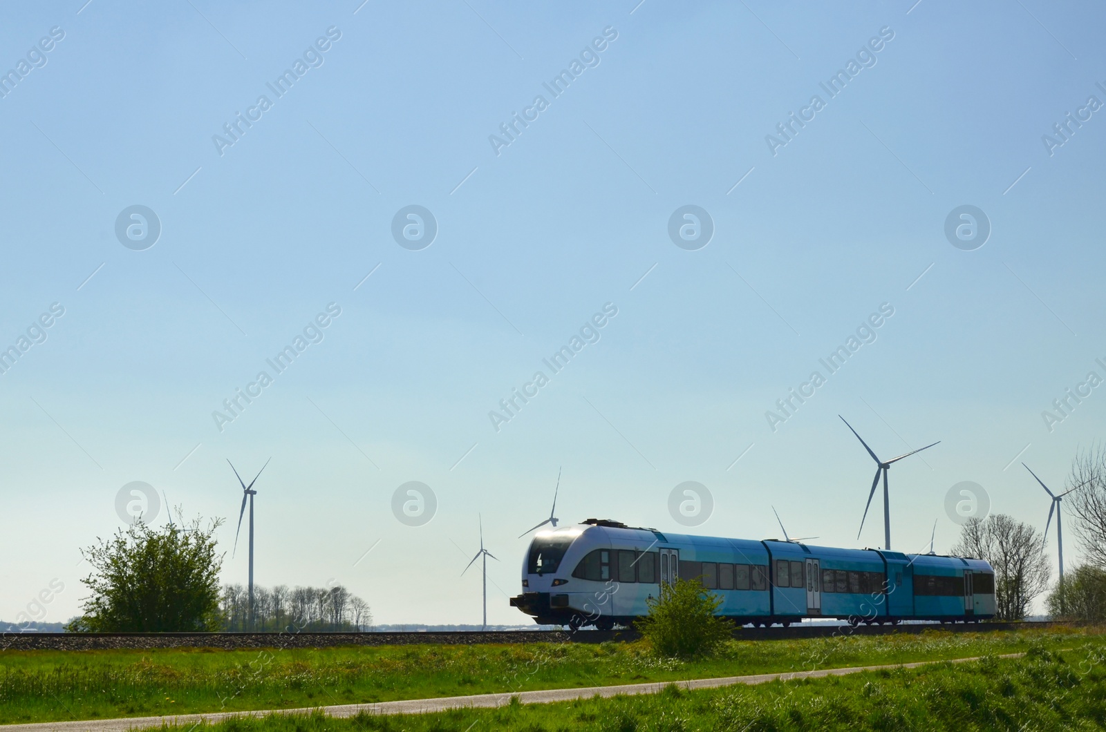 Photo of Railway line with train in countryside on sunny day