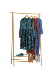 New wardrobe rack with stylish lady's clothes and shoes on white background