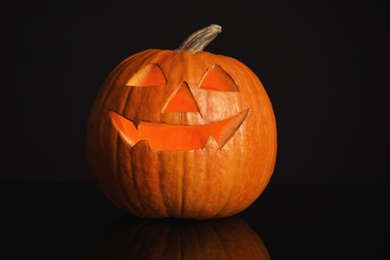 Photo of Halloween pumpkin head. Glowing jack lantern on dark background