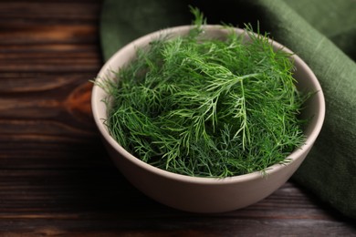 Photo of Bowl of fresh dill on wooden table. Space for text