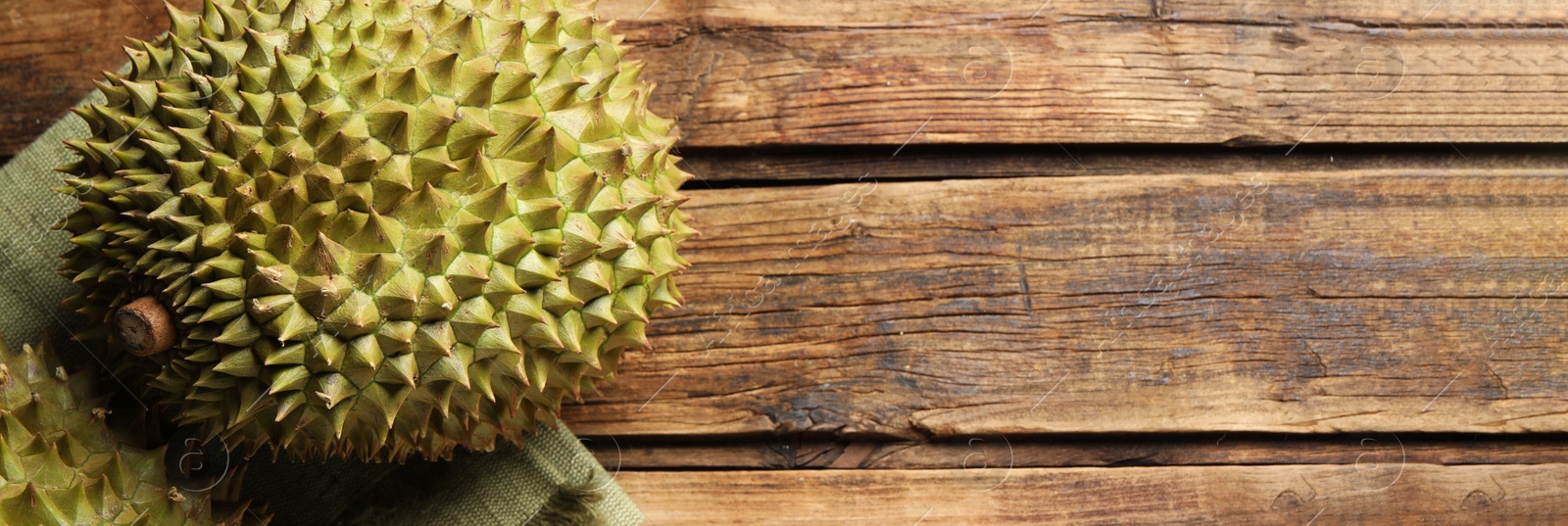 Image of Ripe durians on wooden table, top view with space for text. Banner design