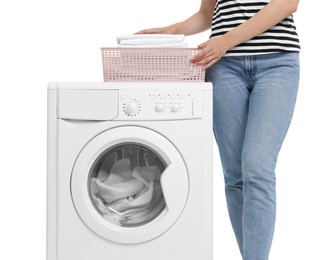 Woman with laundry basket near washing machine on white background, closeup