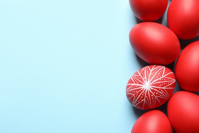 Photo of Flat lay composition of painted red Easter eggs on color background, space for text